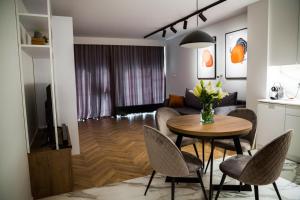 a kitchen and living room with a table and chairs at SMART Apartament BASEN & SPA UNIA ART RESIDENCE Centrum, garaż free,faktura VAT in Lublin
