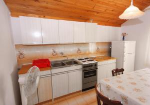 eine Küche mit einem Herd, einer Spüle und einem Tisch in der Unterkunft Apartment Jezera 5093a in Jezera + 19 Fotos