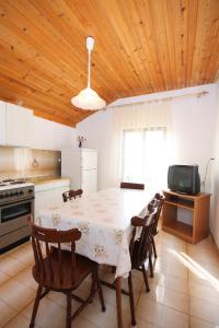 eine Küche mit einem Tisch, Stühlen und einem Tisch in der Unterkunft Apartment Jezera 5093a in Jezera