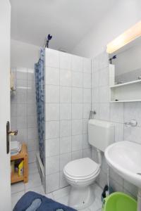 La salle de bains blanche est pourvue de toilettes et d'un lavabo. dans l'établissement Apartments with a parking space Murter - 5084, à Murter