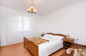 a white bedroom with a bed and a window at Apartments with parking space Murter - 5084 in Murter