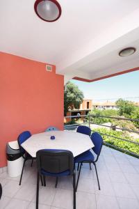 a table and chairs in a room with a balcony at Apartments with parking space Murter - 5084 in Murter