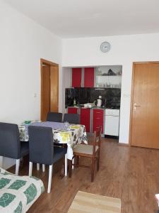 a dining room with a table and chairs and a kitchen at Apartments and rooms with parking space Jezera, Murter - 5082 in Jezera