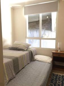 a bedroom with a bed and a window at Grande Departamento, Frente al Mar, Equipado. in Valparaíso