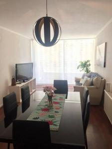 a living room with a table with chairs and a television at Grande Departamento, Frente al Mar, Equipado. in Valparaíso