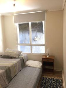 Schlafzimmer mit einem Bett und einem Fenster in der Unterkunft Grande Departamento, Frente al Mar, Equipado. in Valparaíso