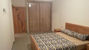 a bedroom with a bed and a sliding door at Saidia Caracas AS in Saïdia