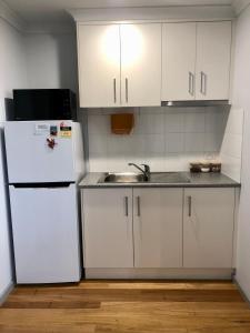 uma cozinha com um frigorífico branco e um lavatório em The Weekender em Peterborough