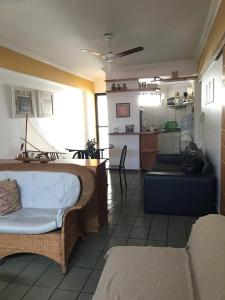 a living room with a couch and a kitchen at Apartamento Na Ponta Verde in Maceió