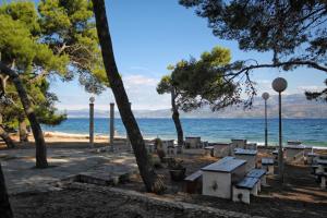 un parco con tavolo da picnic e la spiaggia di Apartments by the sea Supetar, Brac - 6040 a Supetar (San Pietro di Brazza)