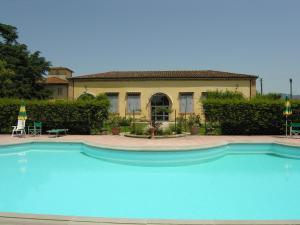 uma grande piscina azul em frente a uma casa em Villa Senni em Scarperia