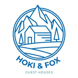 een logo voor een pension met bergen bij The Blackhouse Cottage in Hokitika