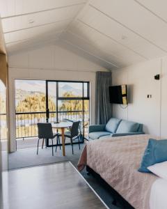 a bedroom with a bed and a table and a couch at Driftaway Queenstown in Queenstown