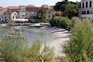 a river with boats on it next to buildings at Apartments with parking space Postira, Brac - 727 in Postira +7 photos