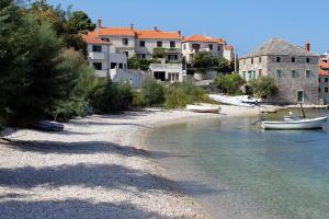 a beach with a small boat in the water at Apartments with a parking space Postira, Brac - 727 in Postira