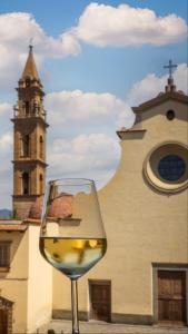 a glass of white wine in front of a church at SPIRIT OF FLORENCE Boutique Rooms in Florence
