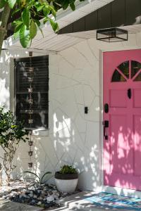una puerta rosa en el lateral de una casa en Welcome to The Bray Escape 4 miles to Siesta Key, en Sarasota