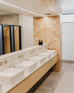 a bathroom with four sinks and a large mirror at Driftaway Queenstown in Queenstown