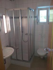 y baño con ducha, aseo y lavamanos. en Apartments Strandburg Kroatien, en Živogošće