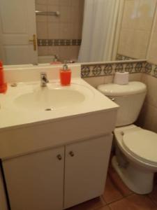 a bathroom with a white sink and a toilet at Departamento en Condominio La Puntilla Villarrica in Villarrica