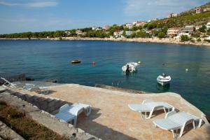 un groupe de chaises et de bateaux dans l'eau dans l'établissement Apartments by the sea Bilo, Primosten - 8364, à Primošten