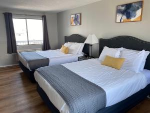 una camera d'albergo con due letti e una finestra di Ways Motel a Hampton Beach