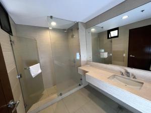 y baño con lavabo y ducha. en Anvaya Cove Short Term Rental Condos en Morong