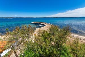 einen Strand mit einer Gruppe von Booten im Wasser in der Unterkunft Apartments by the sea Tkon, Pasman - 8244 in Tkon