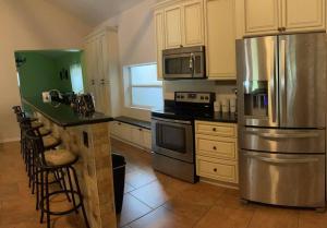 a kitchen with a stainless steel refrigerator and a counter at The Piano House in Orlando +21 photos