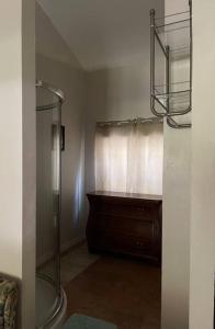 a bathroom with a shower and a wooden dresser at The Piano House in Orlando