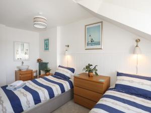 a bedroom with two beds with blue and white stripes at Ty Haf in Rhosneigr