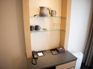 a room with a counter with a telephone and shelves at Hotel Keihan Kyoto Ekiminami in Kyoto