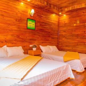 two beds in a room with wooden walls at Homestay 368 in Chung Cap