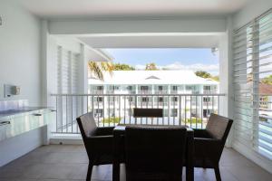 een balkon met een tafel en stoelen erop bij Beach Club Port Douglas 3 Bedroom Penthouse in Port Douglas