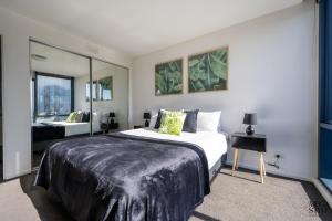 sypialnia z dużym łóżkiem i lustrem w obiekcie Mega Style Apartments Mainpoint w Melbourne