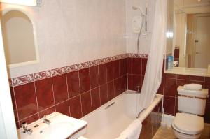 a bathroom with a tub and a toilet and a sink at Central Regent Terrace Apartment in Edinburgh