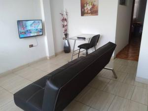 a black couch in a living room with a table at Departamento - Los Mitos del Parque M2 in Chiclayo
