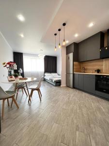 uma cozinha e sala de estar com mesa e cadeiras em Современная квартира в новом доме em Pavlodar