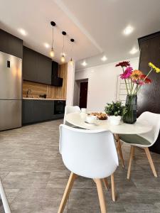 uma cozinha e sala de jantar com uma mesa branca e cadeiras em Современная квартира в новом доме em Pavlodar