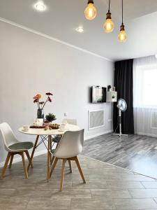 uma sala de jantar com mesa e cadeiras em Современная квартира в новом доме em Pavlodar