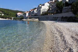 a person standing in the water on a beach at Apartments with WiFi Pucisca, Brac - 11416 in Pučišća +7 photos