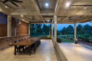 uma sala de jantar exterior com mesa e cadeiras em Brickhouse Bukit Tinggi by Santai Villas em Bentong