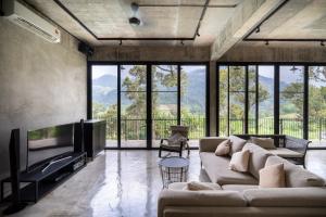 a living room with a couch and a tv at Brickhouse Bukit Tinggi by Santai Villas in Bentong