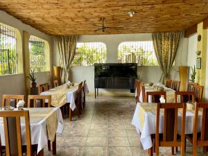a restaurant with tables and chairs and a flat screen tv at Lapu-Lapu Cottages & Restaurant in Mactan