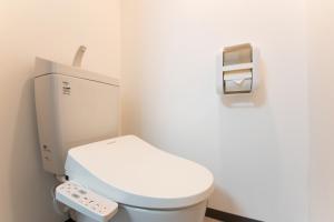 a bathroom with a white toilet with a remote control at Yokohama Sakuragicho Town Hotel in Yokohama