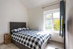 a bedroom with a bed and a window at Stunning 4 bedroom house with Garden, Parking & 3 mins Walking Distance from Train Station in London