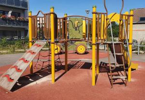 um parque de diversões amarelo com um escorrega num parque em Le Bienvenue à Colmar, parking gratuit & balcon em Colmar
