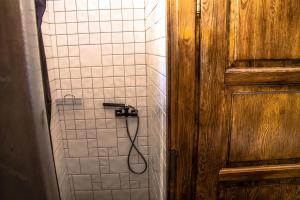 a shower with a hose in a bathroom at Angel Hostel in Toruń