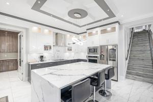 a white kitchen with a large marble counter top at T&T Lodge in Surrey