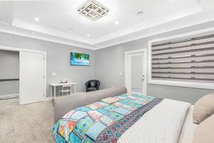 a bedroom with a bed and a chair and a window at T&T Lodge in Surrey